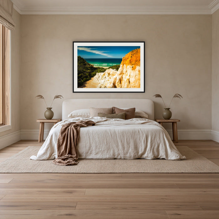 The Pinnacles framed print in black with a white mat, above an ivory linen bed in a bedroom