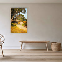 Merimbula Boardwalk Three in an oak frame without a mat, in a cane-panelled hallway