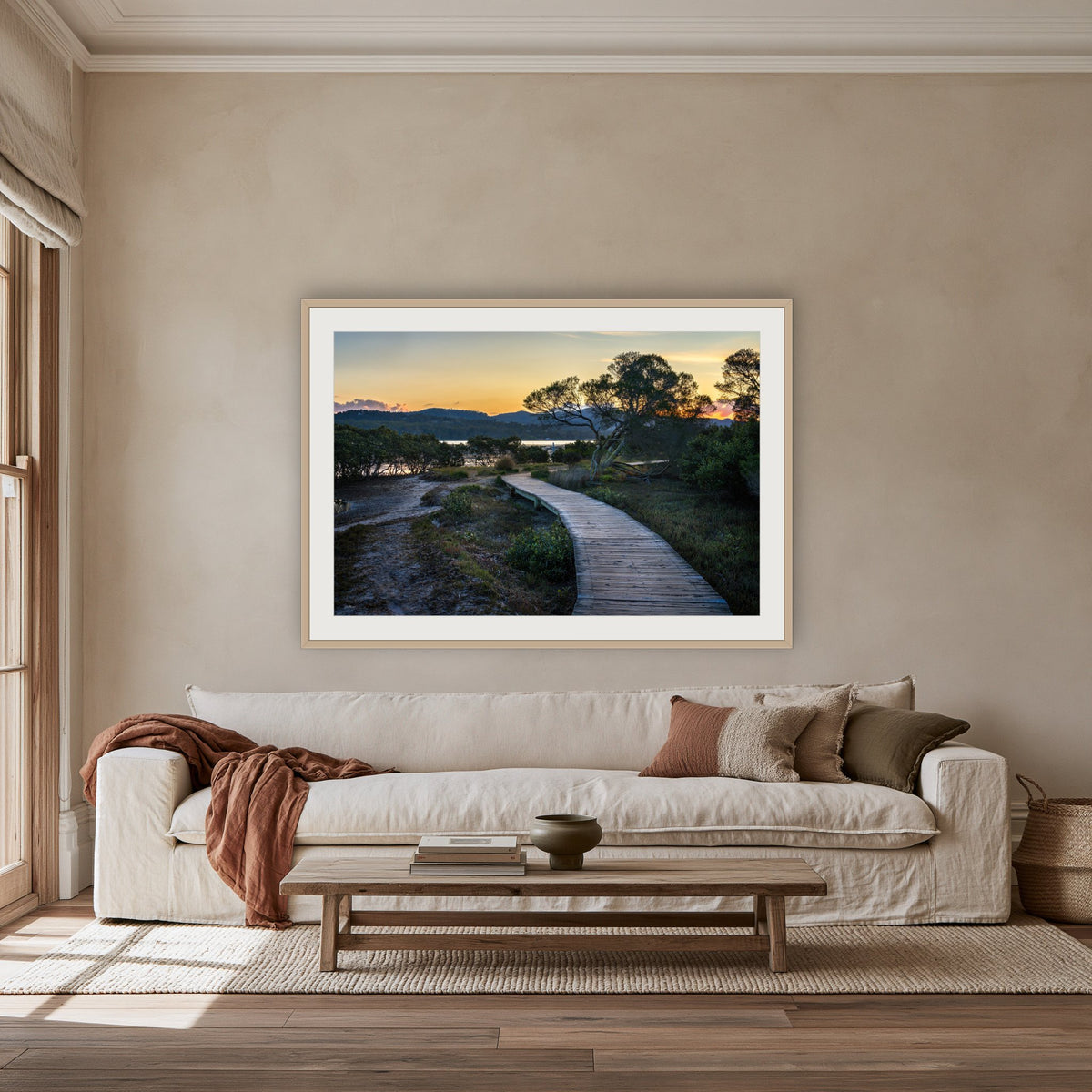 Merimbula Boardwalk at Dusk framed print in oak with a white mat, above an oatmeal linen sofa in a lounge room