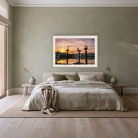 Pelican Sculptures framed print in oak with a white mat, above a linen bed against a sage wall in a bedroom