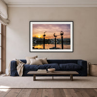 Pelican Sculptures framed print in black with a white mat, above a navy linen sofa in a lounge room