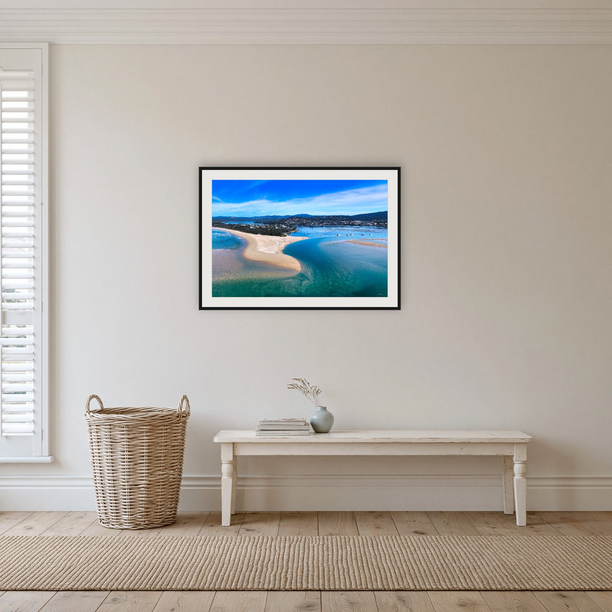 Merimbula Lake and Coastline framed print in black with a white mat, in a hallway