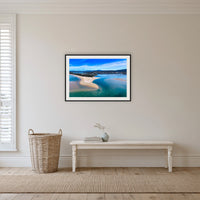 Merimbula Lake and Coastline framed print in black with a white mat, in a hallway