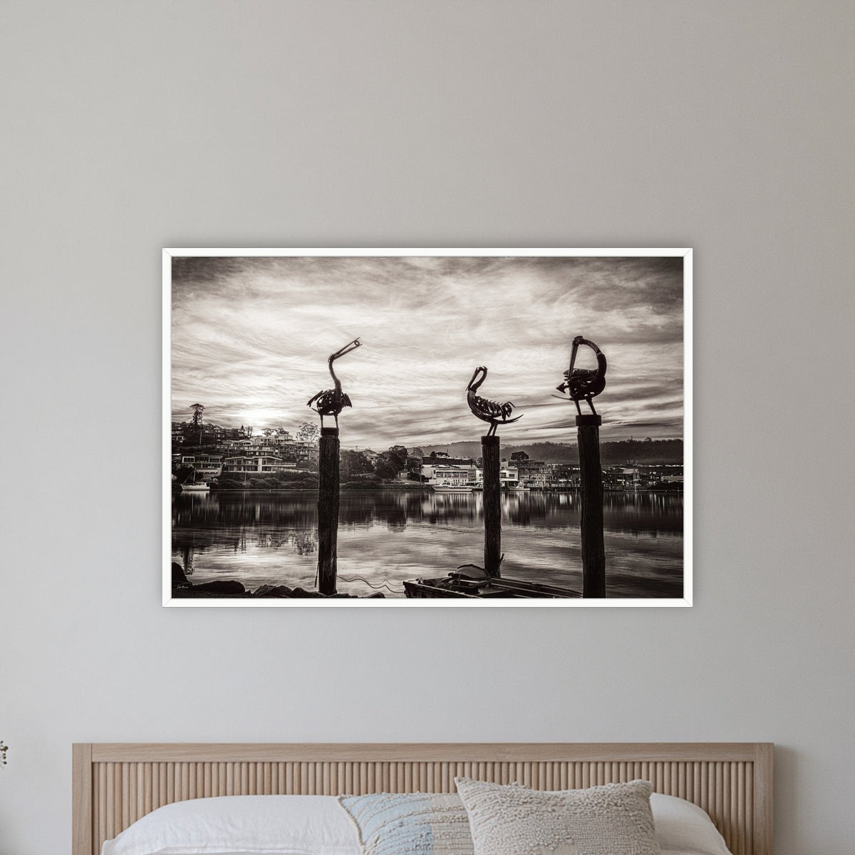 Pelican Sculptures in black and white in a white frame without a mat, on a coastal bedroom wall