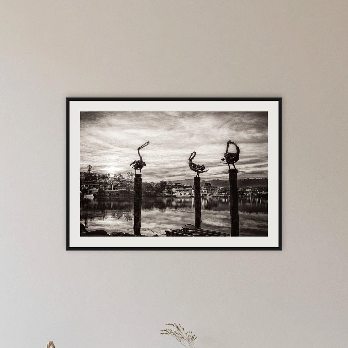 Pelican Sculptures in black and white framed print in black with a white mat, in a hallway