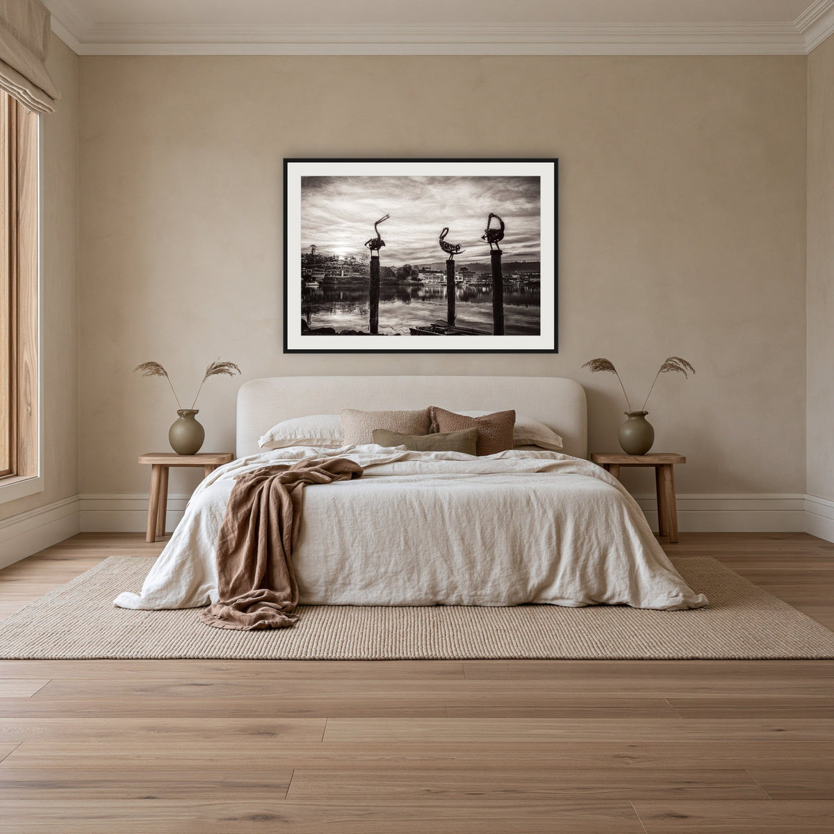 Pelican Sculptures in black and white framed print in black with a white mat, above an ivory linen bed in a bedroom