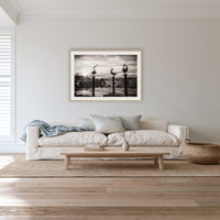 Pelican Sculptures in black and white framed print in oak with a white mat, in a lounge room
