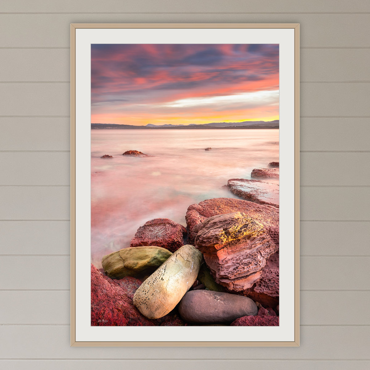 Sunset from Merimbula Wharf framed print in oak with a white mat, on a coastal lounge room wall