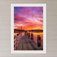 Sunrise over Merimbula Lake framed print in white with a mat, in a coastal lounge room