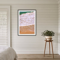 Tura Headlands framed print in black with a white mat, in a coastal bedroom