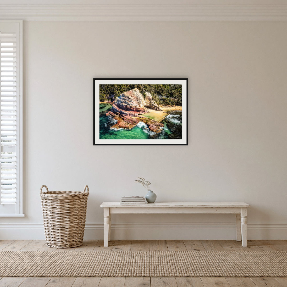Aslings Beach Rock Pool framed print in black with a white mat, in a hallway