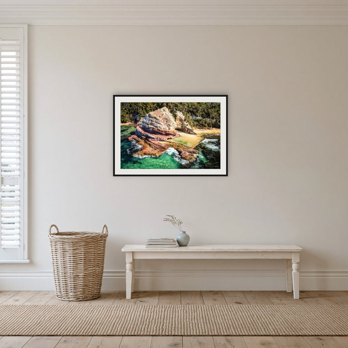 Aslings Beach Rock Pool framed print in black with a white mat, in a hallway