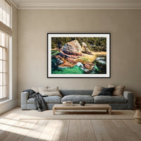 Aslings Beach Rock Pool framed print in black with a white mat, above a dusty blue linen sofa in a lounge room