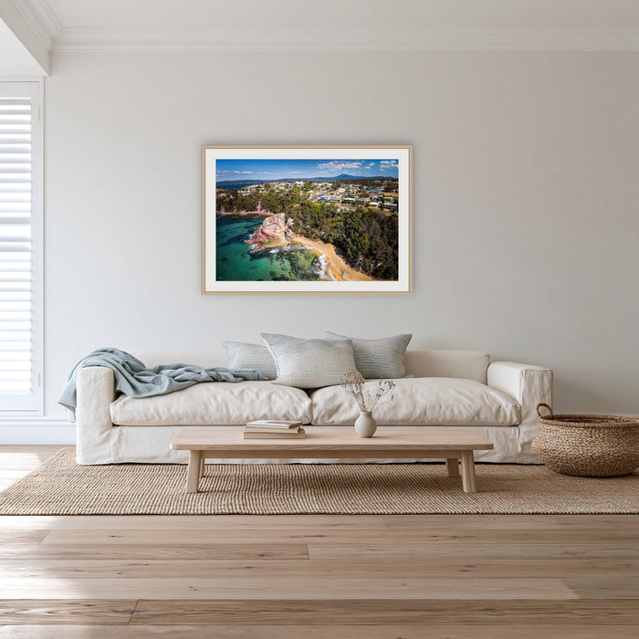 Aslings Beach from the Air framed print in oak with a white mat, in a lounge room