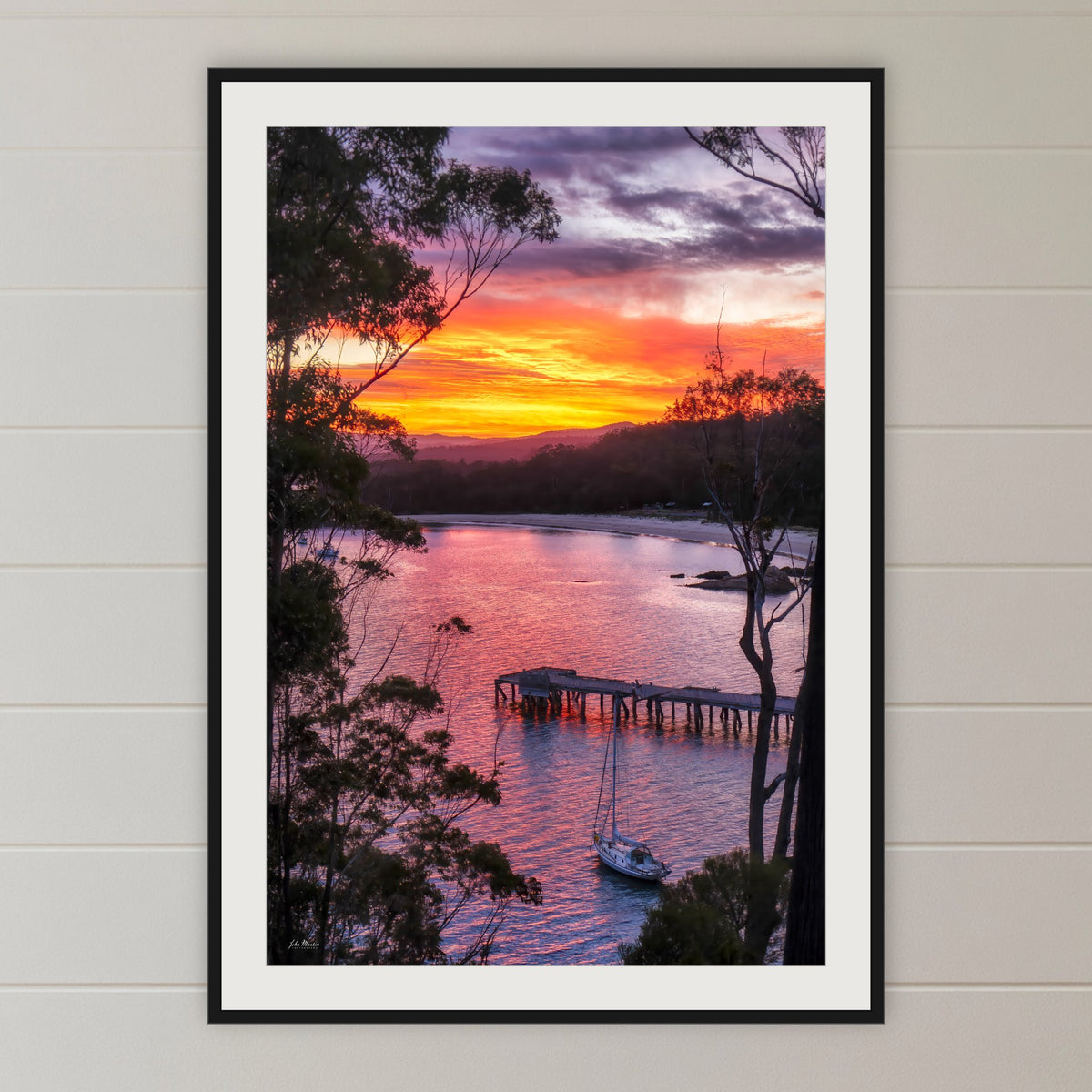 Cattle Bay framed print in black with a white mat, in a shiplap hallway