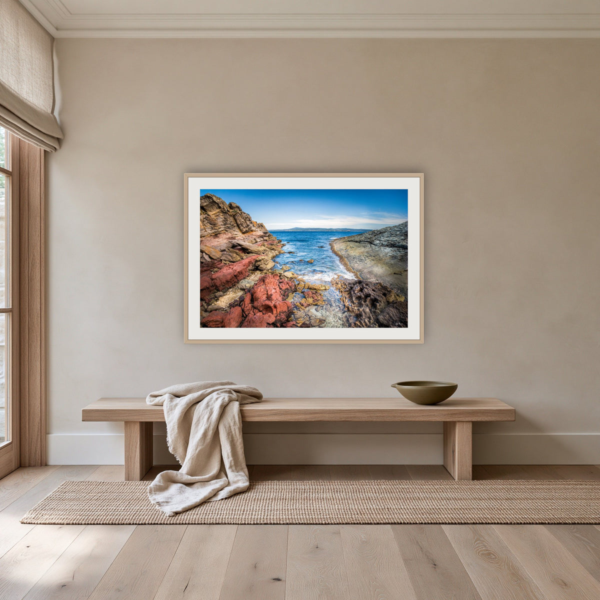 North Head Worang Point framed print in oak with a white mat, above an oak bench in a hallway