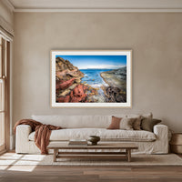 North Head Worang Point framed print in oak with a white mat, above an oatmeal linen sofa in a lounge room