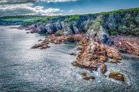 The rocky coastline and bush-topped cliffs at North Head from the air, surf breaking around the point — fine art print