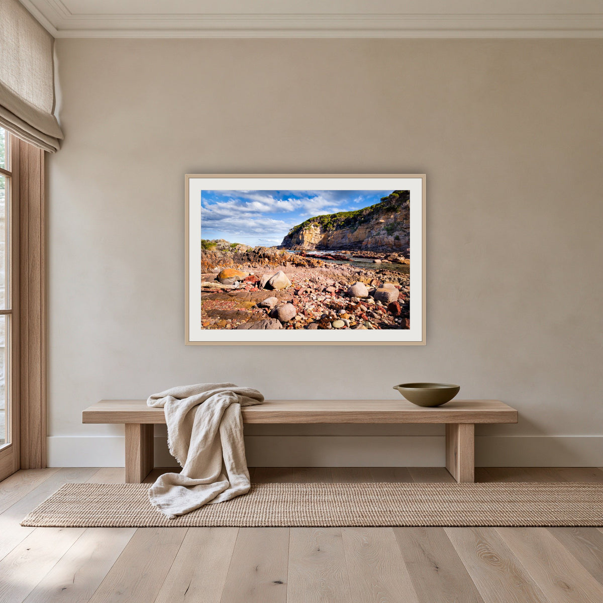 Lennards Island framed print in oak with a white mat, above an oak bench in a hallway