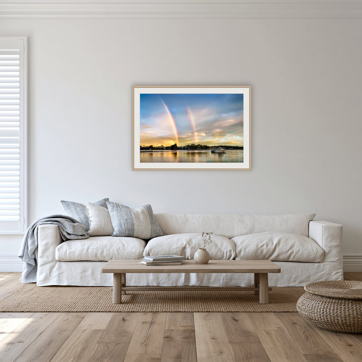 Rainbow over Merimbula Lake framed print in oak with a white mat, in a lounge room