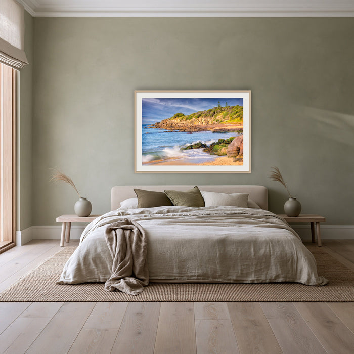 Short Point Cliffs framed print in oak with a white mat, above a linen bed against a sage wall in a bedroom