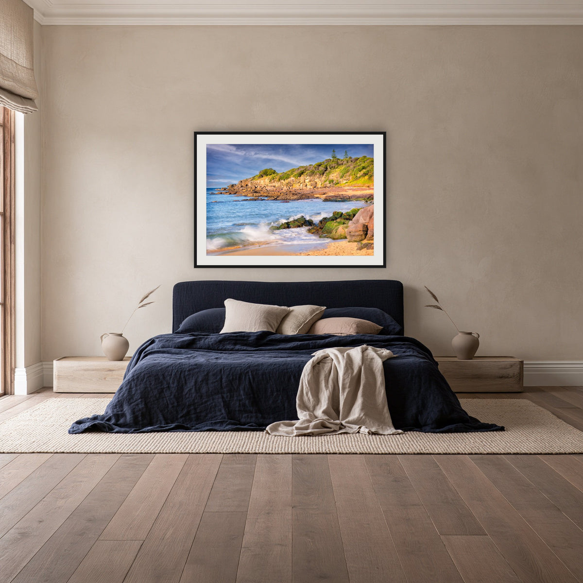 Short Point Cliffs framed print in black with a white mat, above a navy linen bed in a bedroom