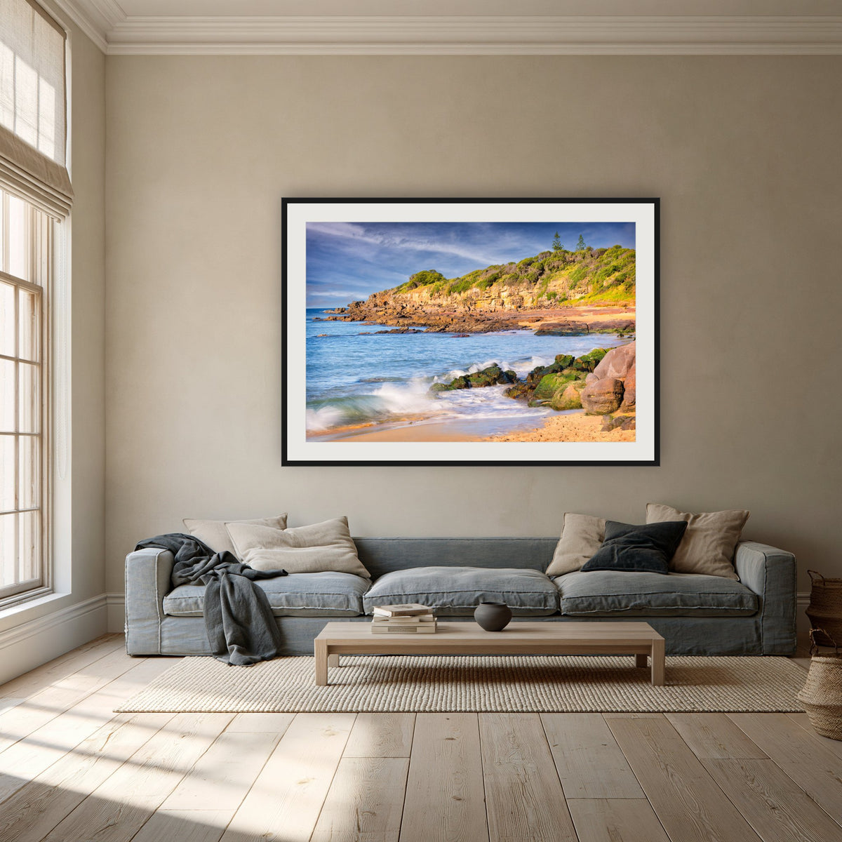 Short Point Cliffs framed print in black with a white mat, above a dusty blue linen sofa in a lounge room