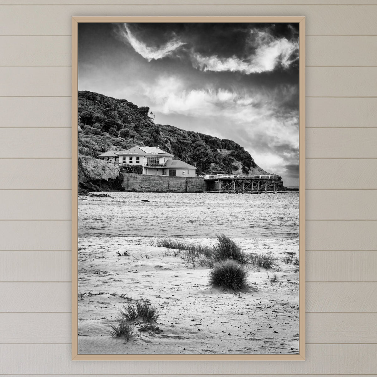 Merimbula Wharf from Main Beach in black and white, in an oak frame without a mat, above the bed in a white coastal bedroom