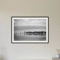 Mitchies Jetty in black and white with colour, framed print in black with a white mat, in a hallway