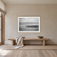Mitchies Jetty in black and white with colour, framed print in oak with a white mat, above an oak bench in a hallway