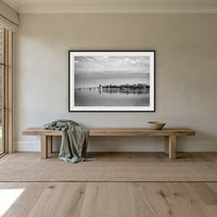 Mitchies Jetty in black and white with colour, framed print in black with a white mat, above an oak bench in a hallway