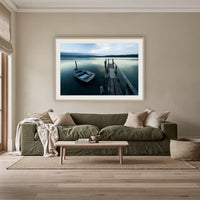 Little Boat at Fishpen Jetty Artistic Treatment framed print in oak with a white mat, above an olive linen sofa in a lounge room