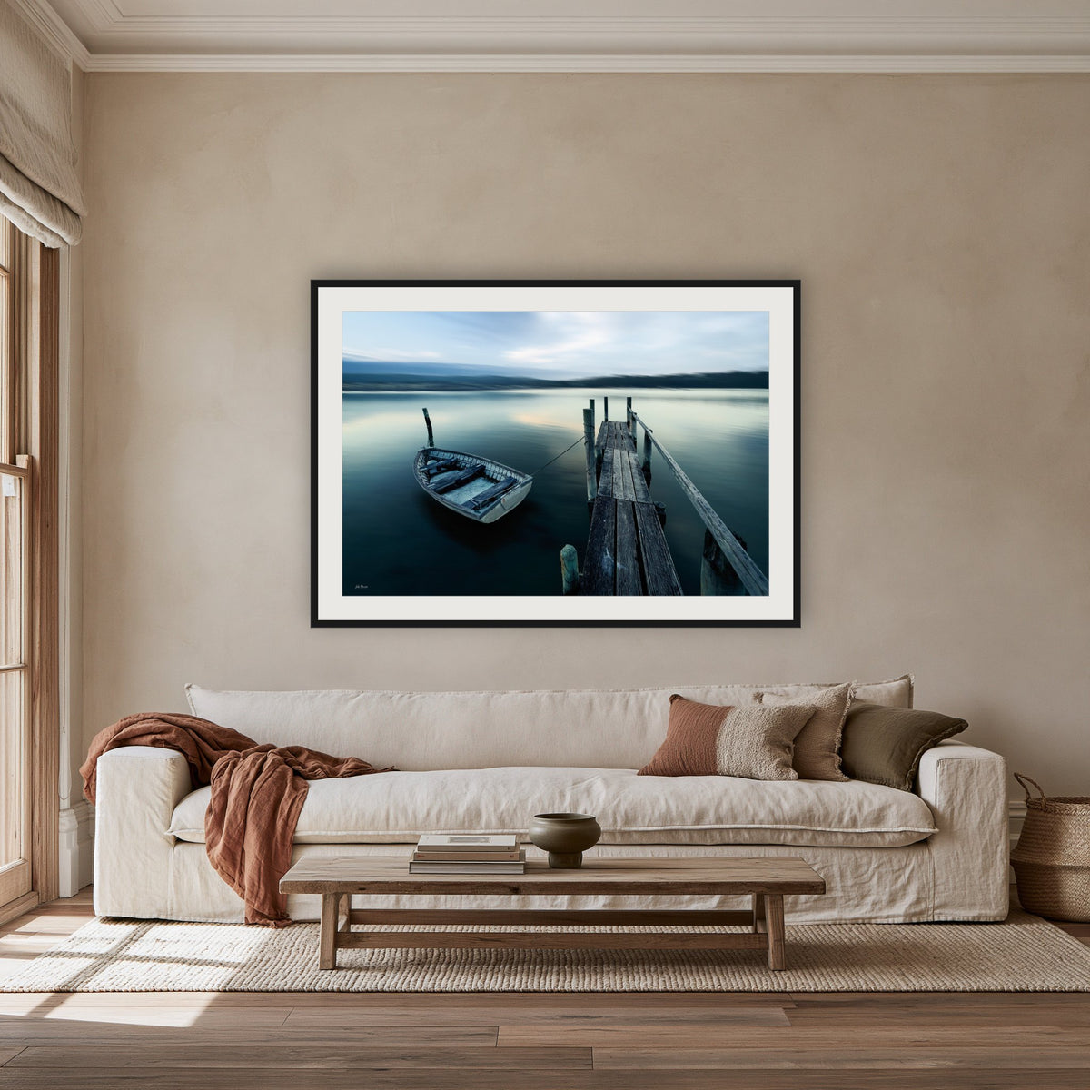Little Boat at Fishpen Jetty Artistic Treatment framed print in black with a white mat, above an oatmeal linen sofa in a lounge room