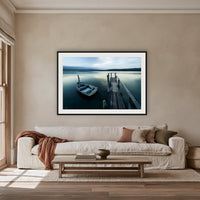 Little Boat at Fishpen Jetty Artistic Treatment framed print in black with a white mat, above an oatmeal linen sofa in a lounge room