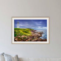 Green Cape Lighthouse framed print in oak with a white mat, in a lounge room