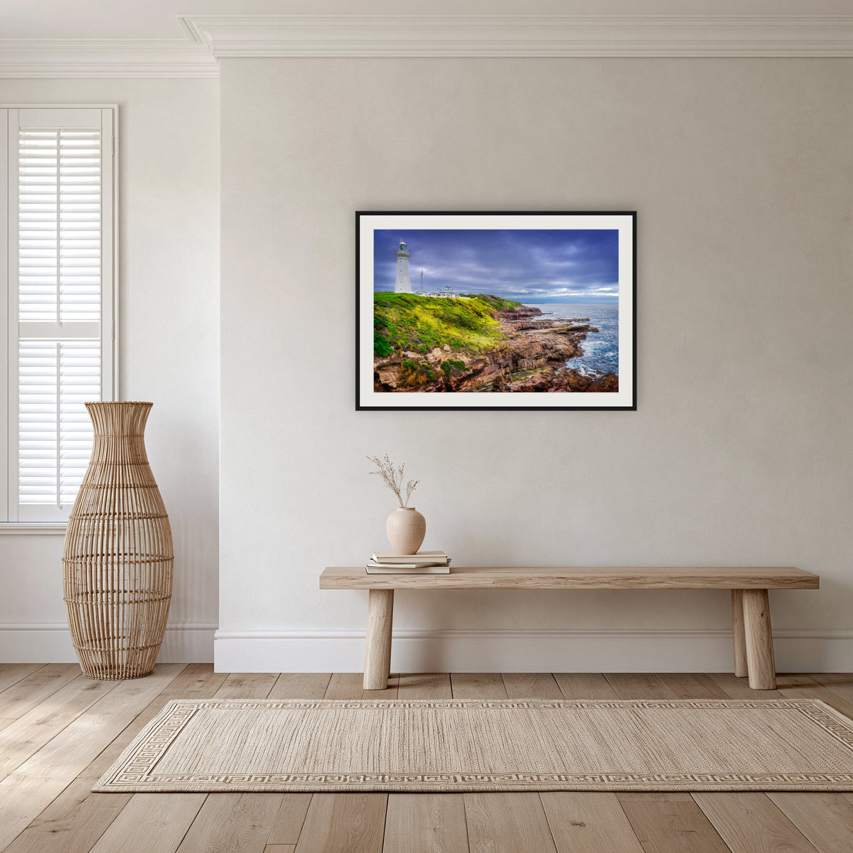 Green Cape Lighthouse framed print in black with a white mat, in a hallway