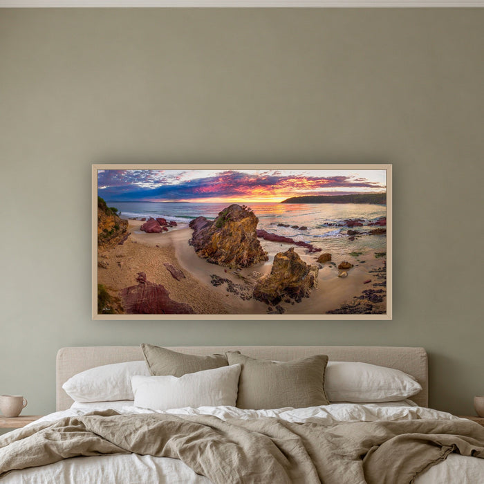 Pambula Beach Sunrise wide panorama in an oak frame above a linen bed on a sage wall — wall art, Sapphire Coast NSW