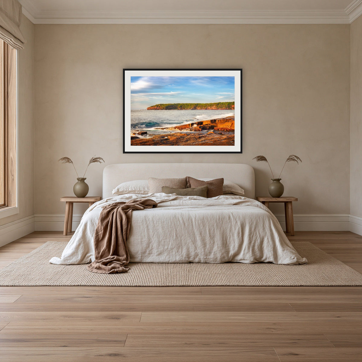 Short Point Sunrise framed print in black with a white mat, above an ivory linen bed in a bedroom
