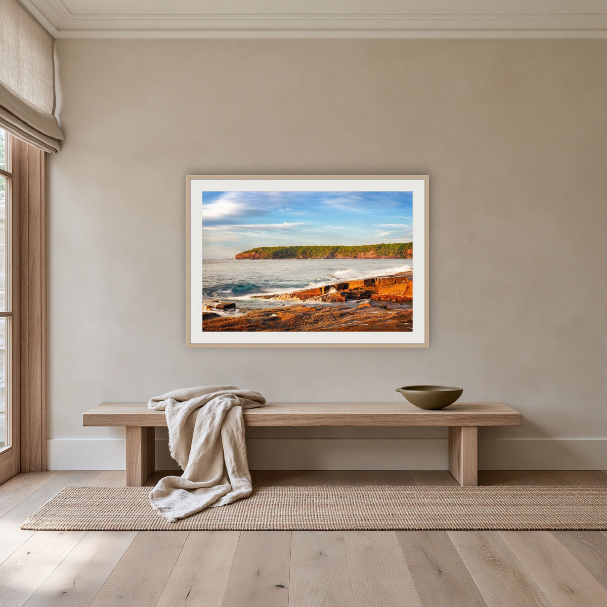 Short Point Sunrise framed print in oak with a white mat, above an oak bench in a hallway
