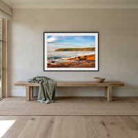 Short Point Sunrise framed print in black with a white mat, above an oak bench in a hallway