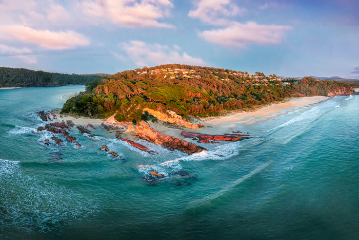 The headland and red rock shelves at Pambula Beach from the air at first light, surf lines running in over turquoise water — fine art print