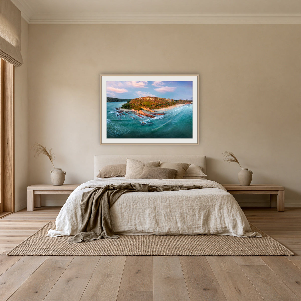 Pambula Beach Seascape framed print in oak with a white mat, above an oatmeal linen bed in a bedroom