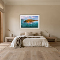 Pambula Beach Seascape framed print in oak with a white mat, above an oatmeal linen bed in a bedroom