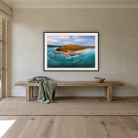 Pambula Beach Seascape framed print in black with a white mat, above an oak bench in a hallway