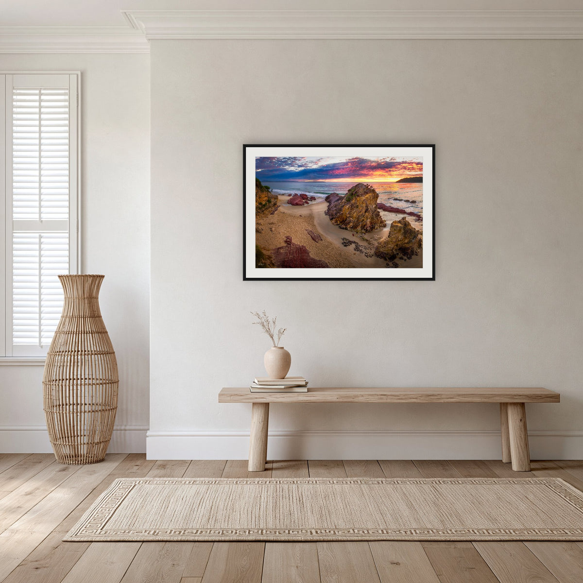 Pambula Beach Sunrise framed print in black with a white mat, in a hallway