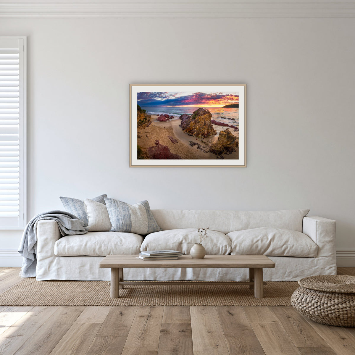 Pambula Beach Sunrise framed print in oak with a white mat, in a lounge room