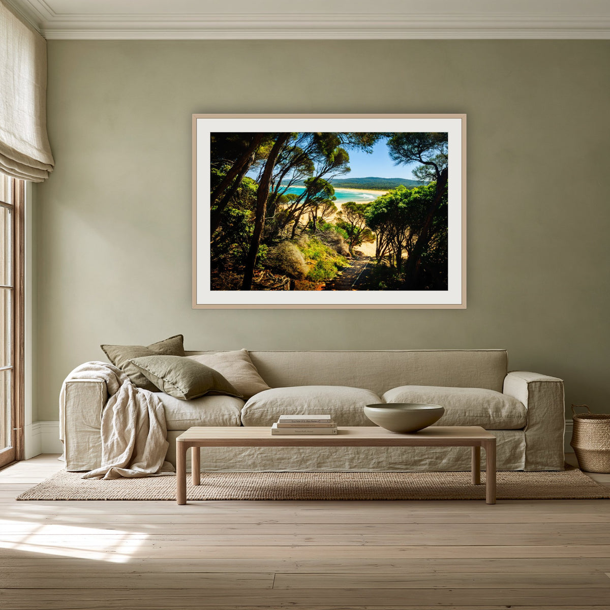 Wallagoot Lake framed print in oak with a white mat, above a linen sofa against a sage wall in a lounge room