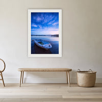 Little Dinghy on Merimbula Lake framed print in white with a mat, in a cane-panelled hallway
