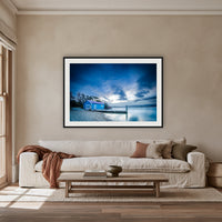 Mitchies Jetty at Dusk, Smooth Lake framed print in black with a white mat, above an oatmeal linen sofa in a lounge room