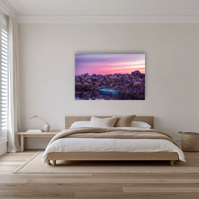 Eden Twofold Hush wall art — a lone blue dinghy against the Eden breakwall at last light, shown as an acrylic panel in a bedroom